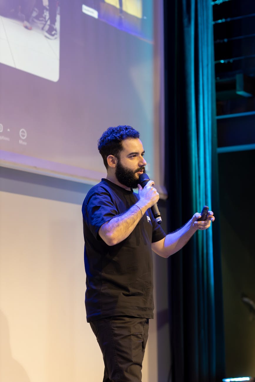 man presenting with microphone on stage